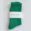 Green sock with 'Le Bon Shoppe' label on a light gray background