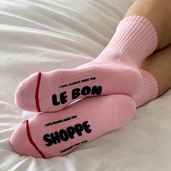 Pink socks with text on a white surface