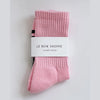 Pink socks with a white label on a light gray background