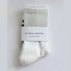 Pair of white socks with a label on a light gray background