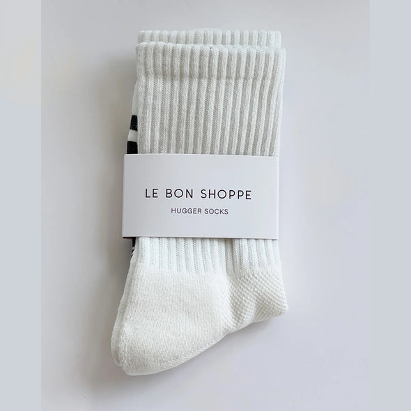 Pair of white socks with a label on a light gray background