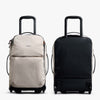Two rolling suitcases, one beige and one black, on a white background.