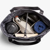 Lite Totepack by Bellroy Arcade Gray with items including a blue towel, black container, and beige bag on a white background