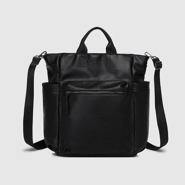 Black leather backpack with shoulder straps on a light gray background