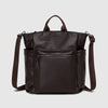 Brown leather backpack with a shoulder strap on a light gray background