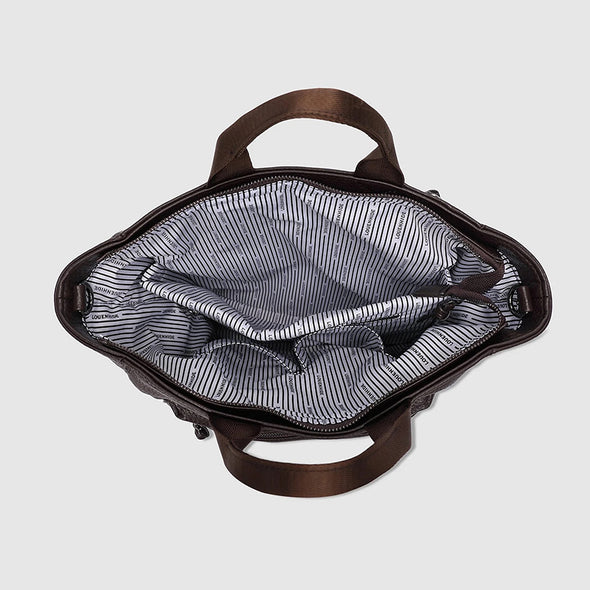 Open brown leather bag with striped lining on a light gray background