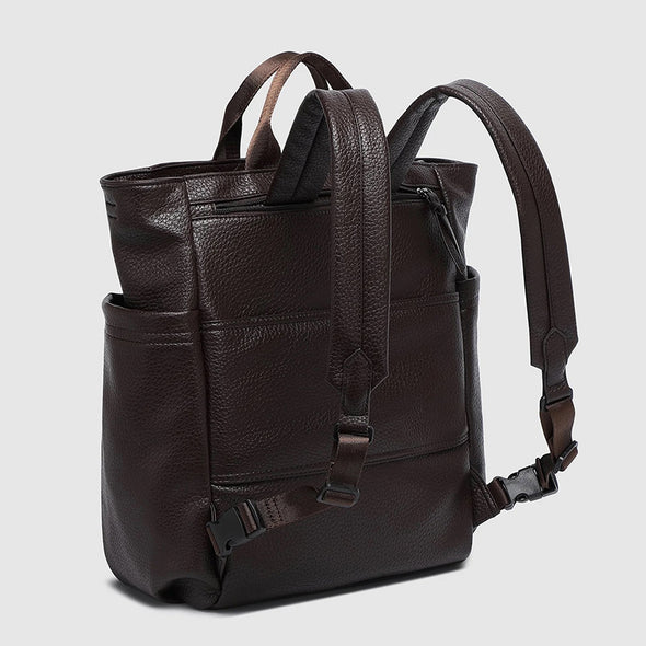 Brown leather backpack on a light gray background