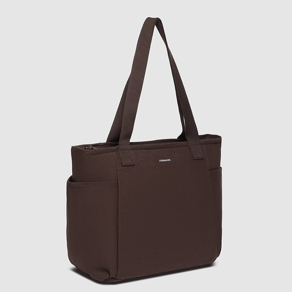 Brown tote bag with a visible brand logo on a light gray background