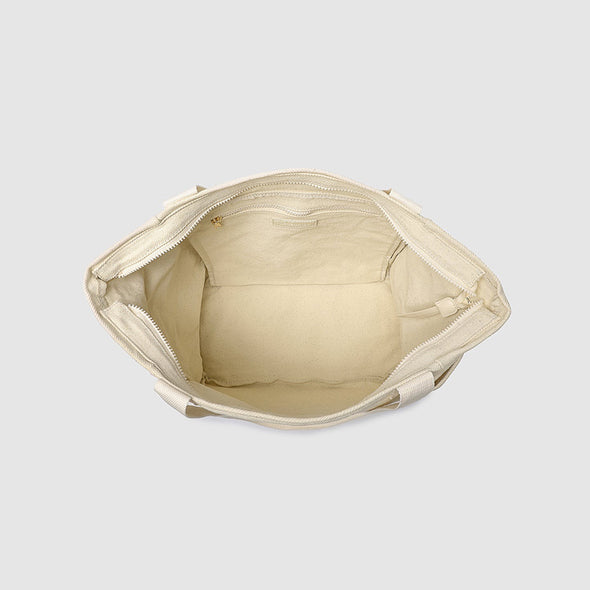 Beige handbag with open top on a light gray background