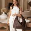 Woman holding a brown handbag in a modern living room