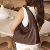 Woman holding a brown leather handbag in an indoor setting