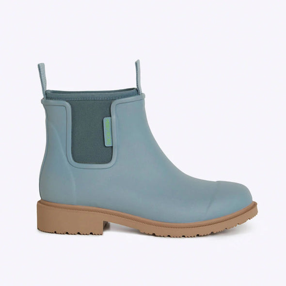 Blue rubber boot with brown sole on a light gray background