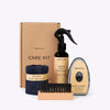 Care kit with rubber boot treatment, microfibre cloth, brush, and buffer on a white background
