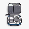 Gray travel organizer with electronic accessories on a white background
