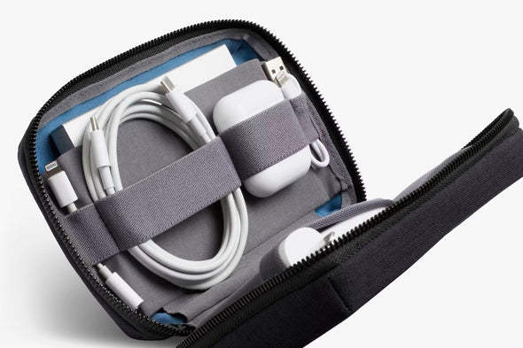 Zipped travel case with electronic accessories on a white background