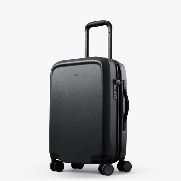 Black suitcase with wheels and handle on a white background