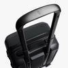Black suitcase with handle and visible brand logo on a white background