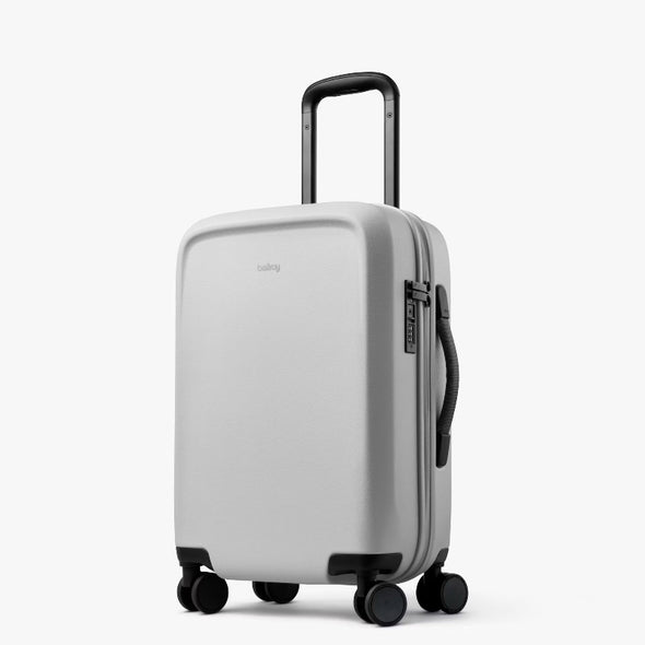 Silver suitcase with wheels and handle on a white background