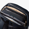 Navy backpack with a compartment holding a laptop on a white background