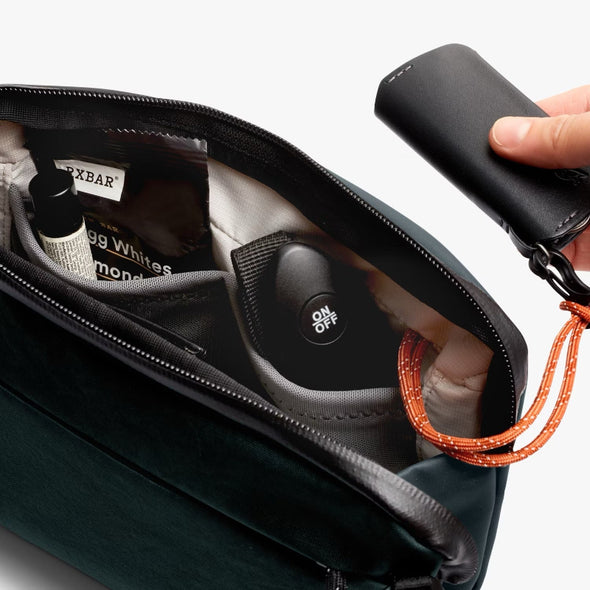 Venture Travel Crossbody by Bellroy Deep Ocean with personal items and a key fob on a white background
