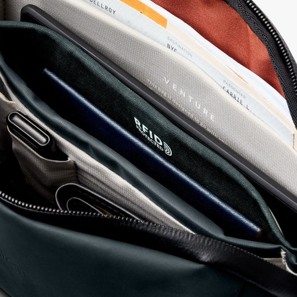 Close-up of a Venture Travel Crossbody by Bellroy Deep Ocean with 'Venture' branding and 'RFID Protected' feature.