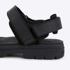 Black sandal with strap design on a white background