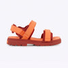 Orange sandal with multiple straps on a white background